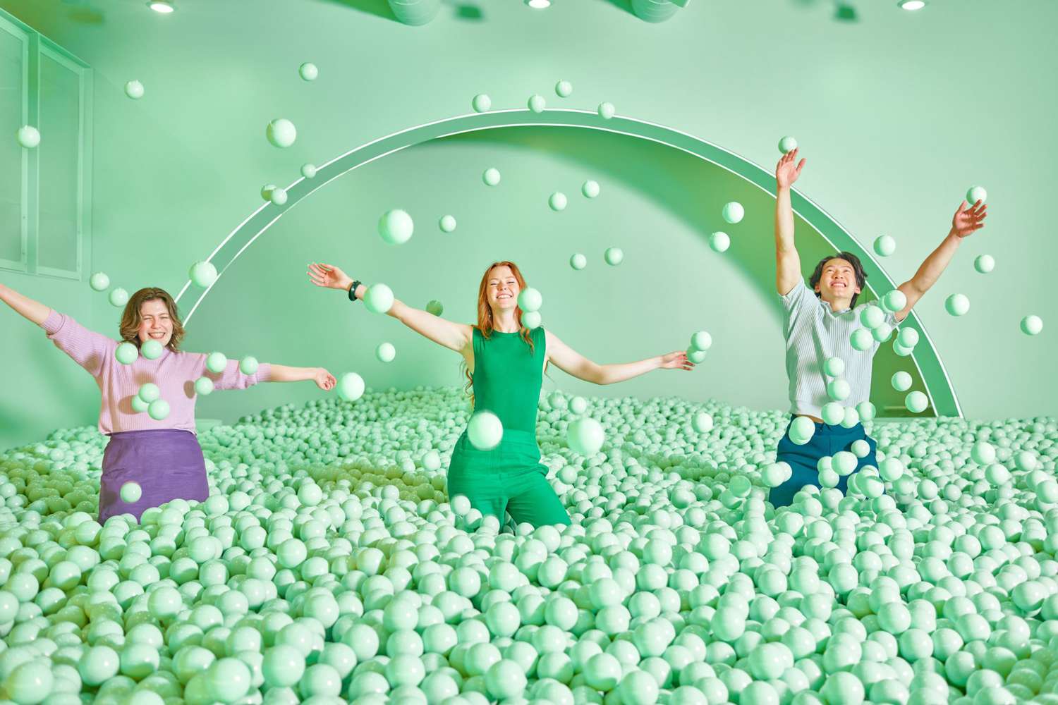 Three adults in ball pit at Color Factory Chicago