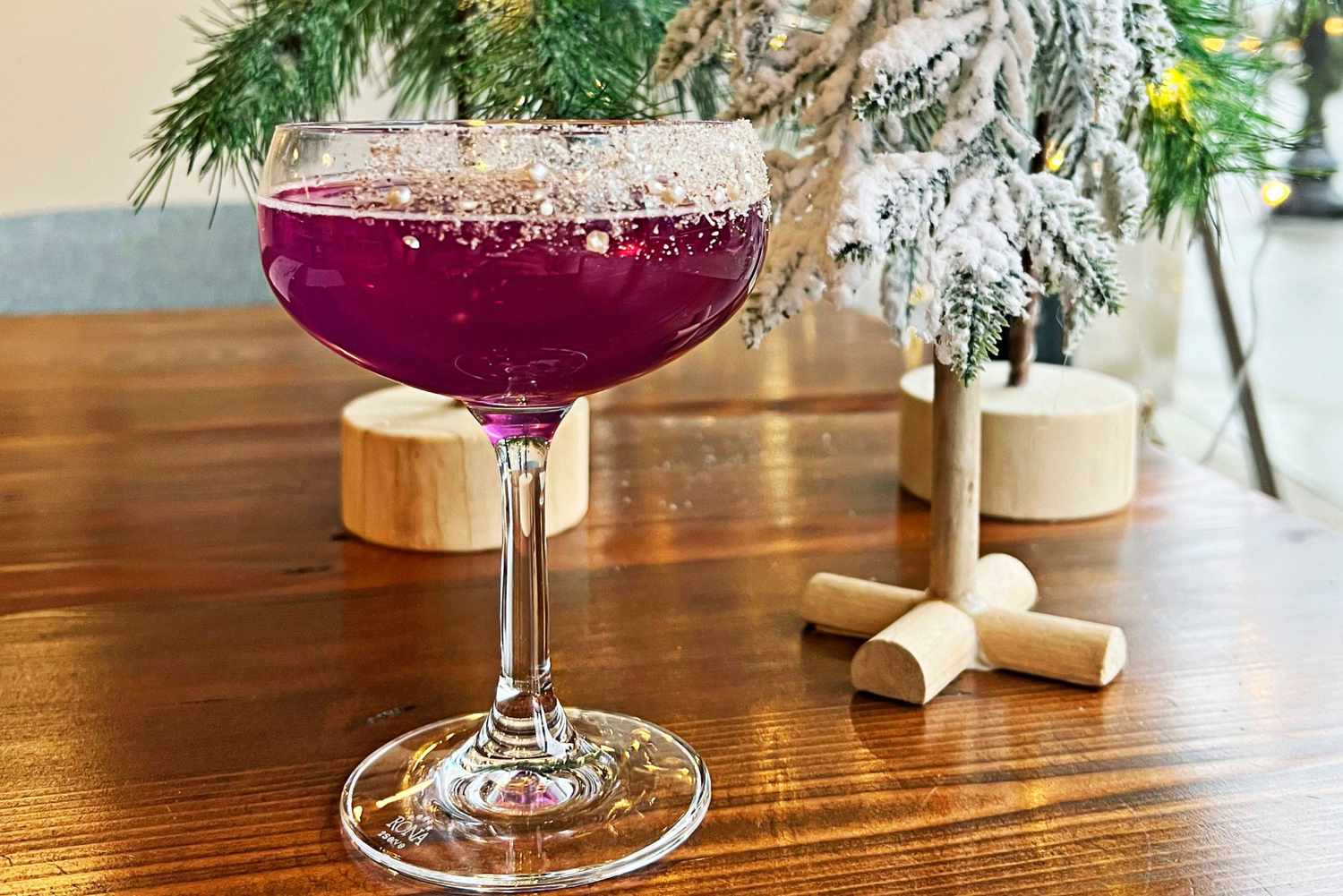 Cranberry-red cocktail with holiday decorating on table
